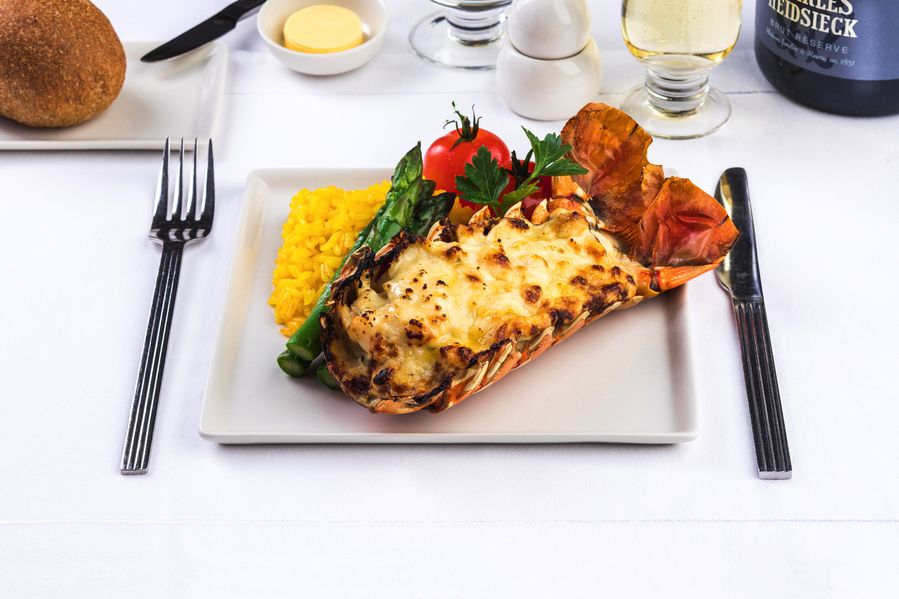 Classic Lobster Thermidor: Western Australian Lobster coated with a creamy wine and herb reduction served in a half shell. Served with a saffron rice pilaf, butter asparagus spears and trussed cherry tomatoes.